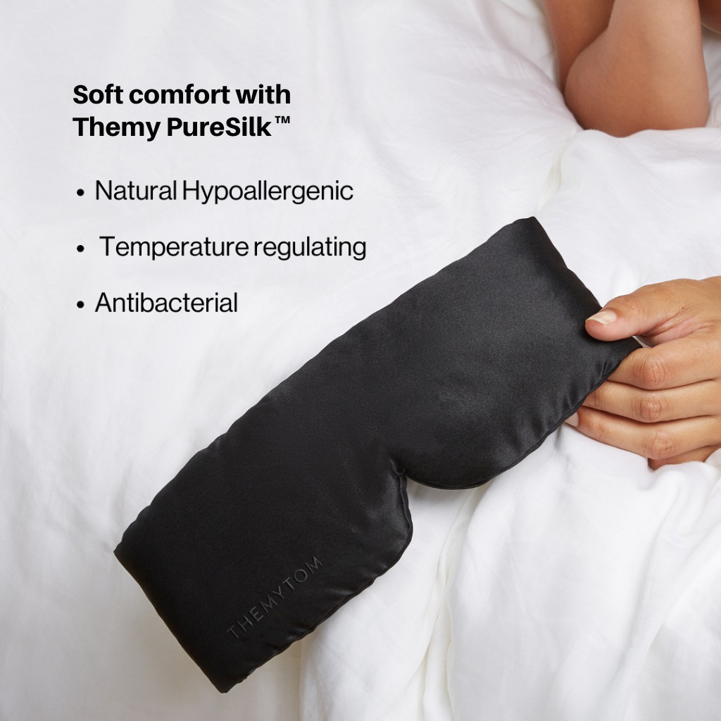 Black satin eye mask held by a hand with text about Themy PureSilk on a white background Nº 21 Ombre Noire