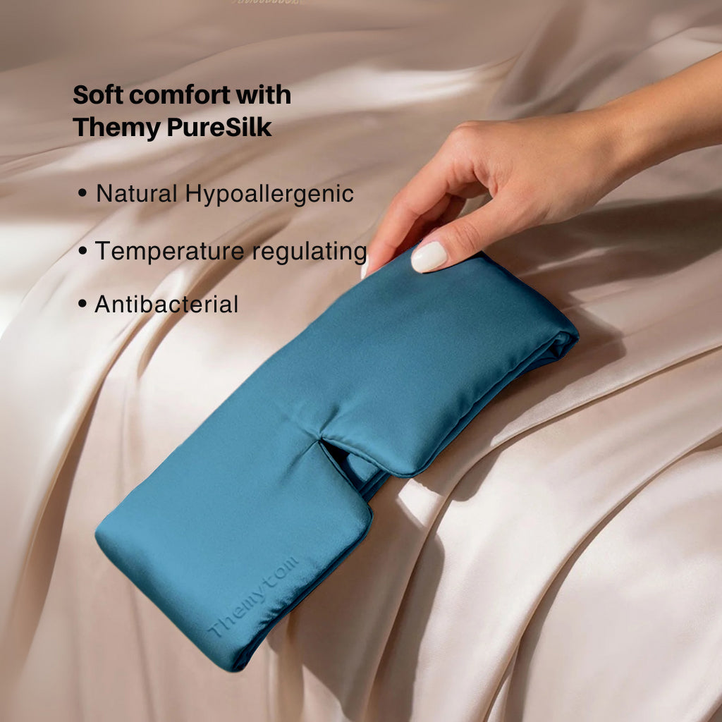 Blue satin pillowcase held by a hand on a beige fabric background with text about Themy PureSilk. Nº 14 Bleu Céleste