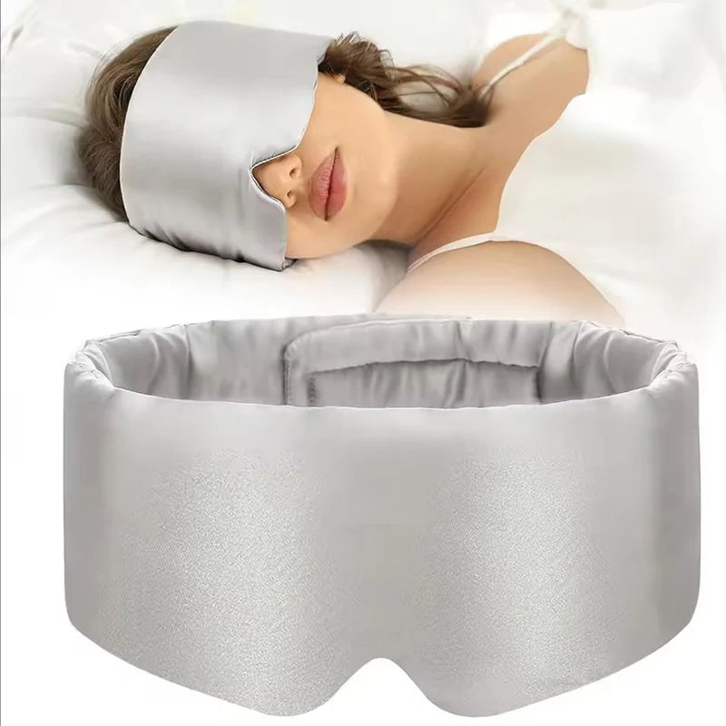 Person wearing a gray sleep mask with a matching pillow on a white Nº 08 Brume d’Argentbackground