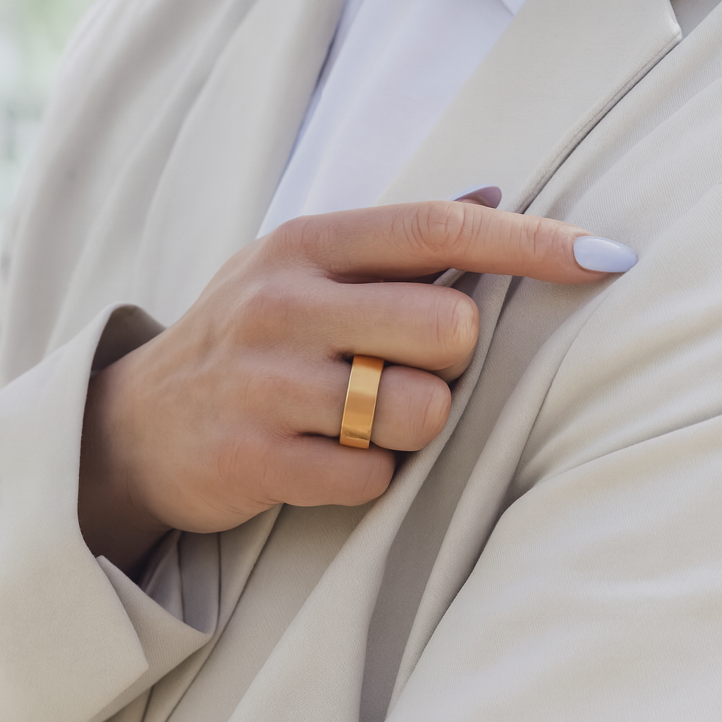 Hand wearing a Gold ring on beige fabric